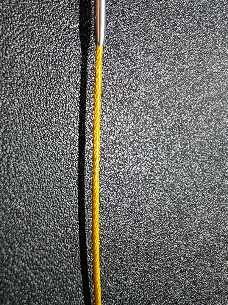 Closeup photo of a cord that comes in the Silian hook set. It is golden and appears to be a wrapped